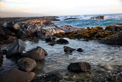 Rocks in sea against sky