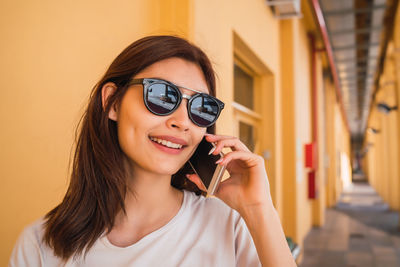 Portrait of a smiling young woman holding camera