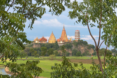 Temple by building against sky