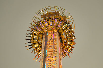 Low angle view of illuminated ferris wheel against clear sky