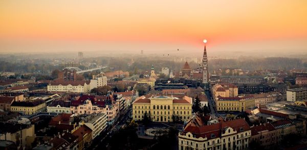 High angle view of buildings in city during sunset