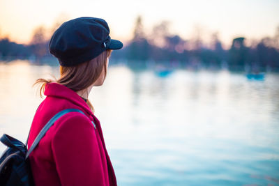 Side view of woman looking at lake during winter