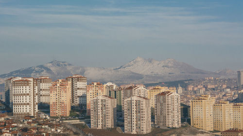 Buildings in city against cloudy sky