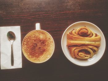 High angle view of coffee served with franzbrotchen on table