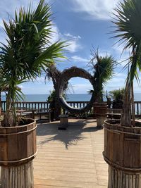 Palm trees by plants against sky