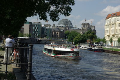 Boats in river with city in background