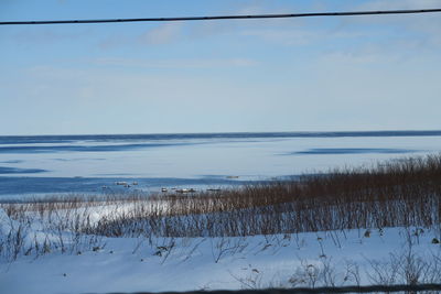 Scenic view of lake against sky during winter