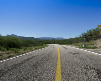 Empty road along countryside landscape