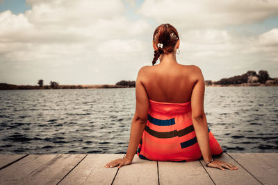 Rear view of woman looking at sea against sky