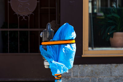 Rear view of man with umbrella on street against building