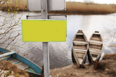 Close-up of yellow sign on shore