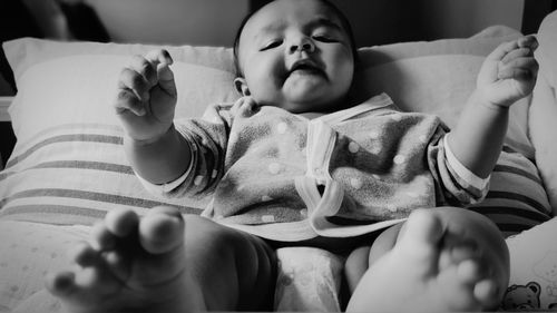 Baby boy lying on bed at home