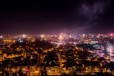 Illuminated cityscape against sky at night