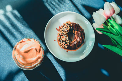 High angle view of breakfast donut and dalgona coffee on blue table