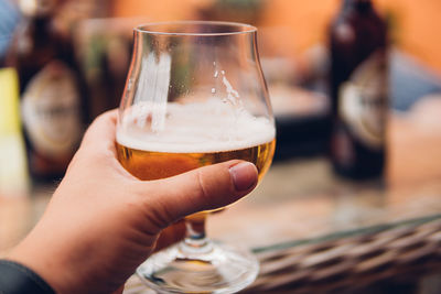 Close-up of hand holding beer glass