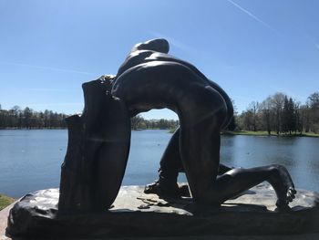 Sculpture in lake against clear sky