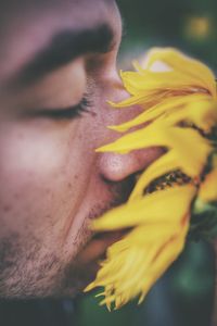 Close-up portrait of man with yellow flower