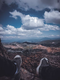 Low section of person on landscape against sky