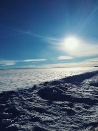 Scenic view of sea against bright sun