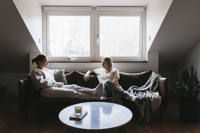 Homosexual couple sitting on sofa and talking