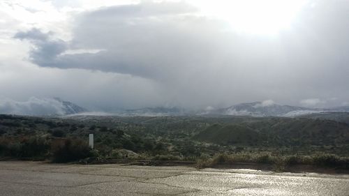 Scenic view of mountains against cloudy sky