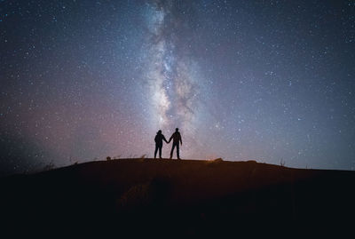 Silhouette man standing against sky at night