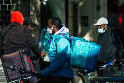 Rear view of people walking in city during winter