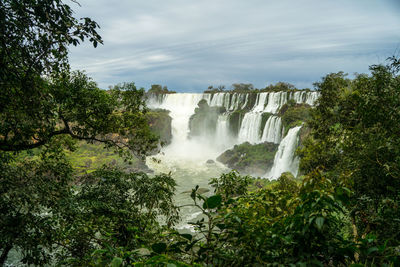 Scenic view of waterfall against sky in iguazu