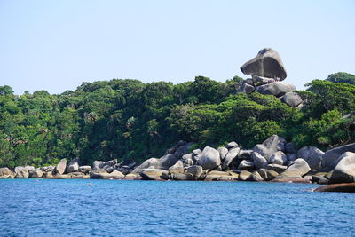 View of rocks in sea against clear sky