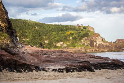 Scenic view of beach against cloudy sky