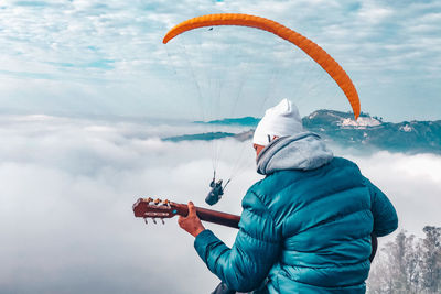 Man holding umbrella against sky during winter