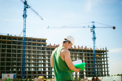 Man standing against construction buildings