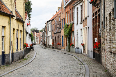 Footpath amidst buildings in town of brugge