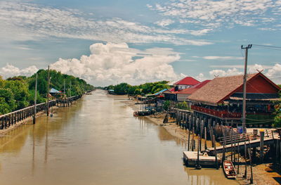 River amidst houses and buildings against sky