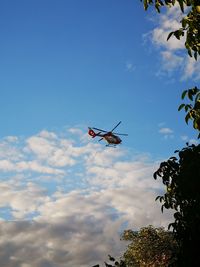 Low angle view of helicopter flying in sky