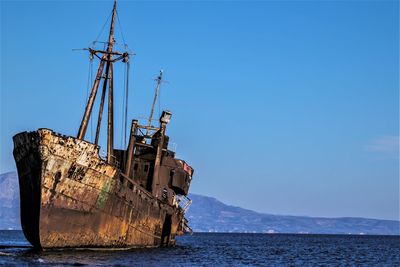 Abandoned ship by sea against sky
