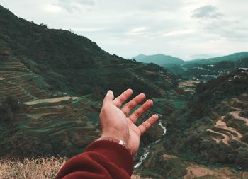 Midsection of person on mountain against sky