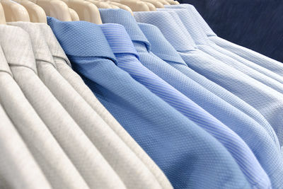 Close-up of clothes hanging against blue sky