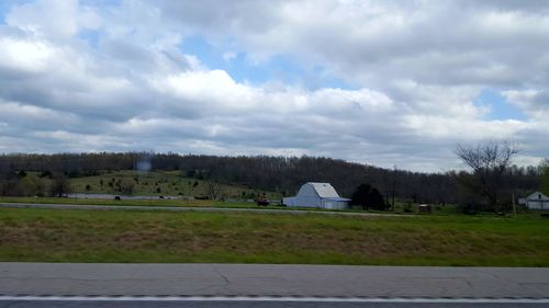 Scenic view of grassy field against cloudy sky