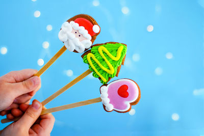 Close-up of hand holding ice cream against blue sky