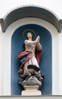 Low angle view of angel statue against building