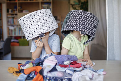 Cute kids with basket on head at home