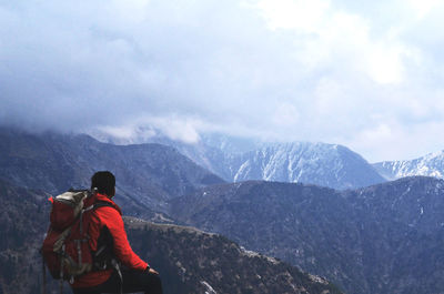 Rear view of man standing on mountain during winter