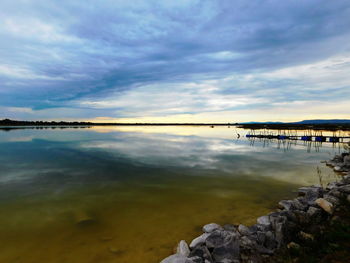 Scenic view of calm lake against cloudy sky