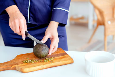 Girl in pajamas prepares breakfast. proper nutrition. the girl makes a salad of avocado 