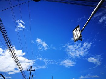 Low angle view of trees against blue sky