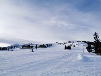 Group of people on snow covered land against sky