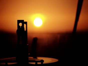 Close-up of silhouette table against sea during sunset