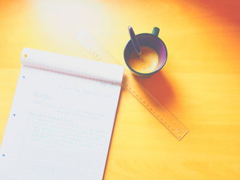 High angle view of open book and drink on table