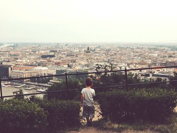 Rear view of boy looking at cityscape